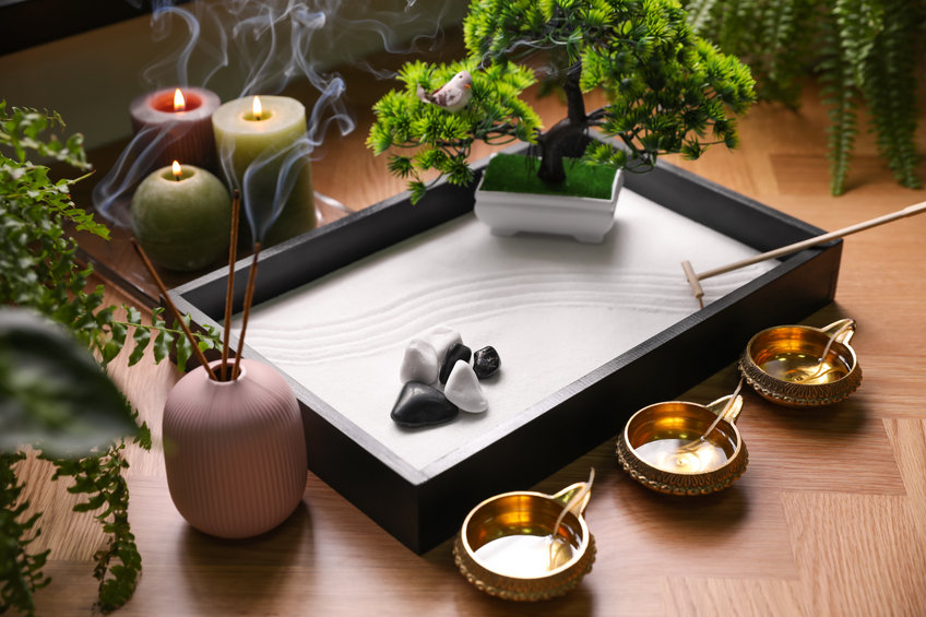 Beautiful miniature zen garden, incense sticks and oil lamps on table