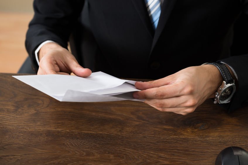 Businessman With Envelopes At Desk